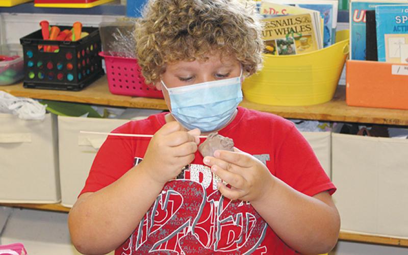 Stacy Van Buskirk/svanbuskirk@cherokeescout.com  Zayden Wallace, a rising fifth-grader, works closely blending the clay around the mouth of his pinch pot face during Mike Lalone’s class in the 21st Century Program at Andrews Elementary School on June 24.