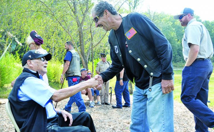 Patrons at the Veterans Educational Appreciation Day event show respect to 93-year-old U.S. Army veteran Reuben Taylor (left), who fought in the European Theatre of World War II.