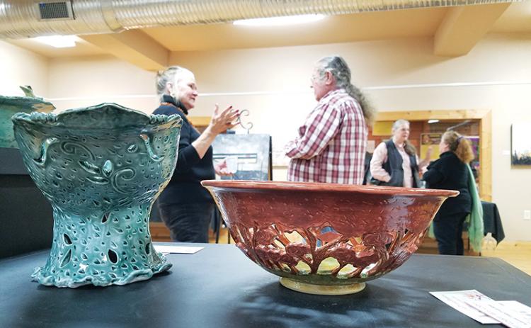 The “Fashioned in the Clay” show displays a variety of items, from practical to decorative, including Lisa Proper’s intricate fruit and centerpiece bowls. In the background, Elo-ly Bailey, David Vowell, Kathy Ross and Proper hold conversations during the exhibit’s opening.