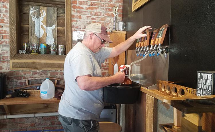 Terry Vaughn fills a growler with Bimbo blond ale for a customer at Snowbird Mountains Brewery in Andrews on Saturday. Photo by Samantha Sinclair