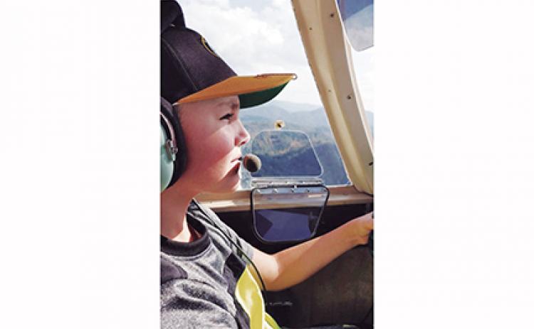 Timothy Raxter flies a plane for the first time with assistance from airport manager Garland Trull. The Western Carolina Youth Aviation Foundation is hoping to give more kids the same opportunity Raxter had.