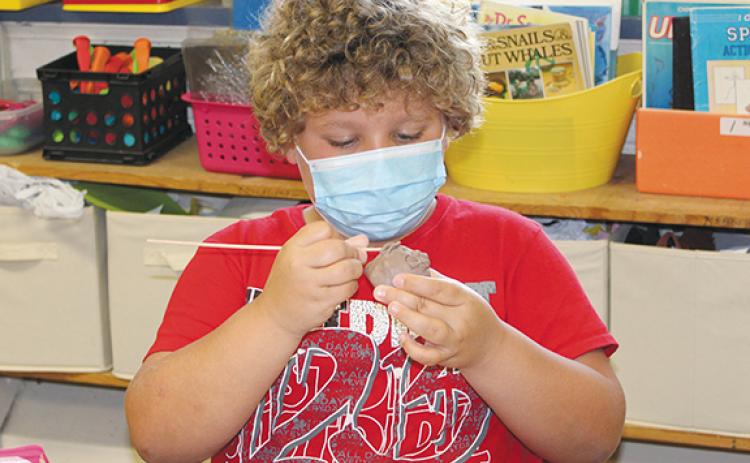 Stacy Van Buskirk/svanbuskirk@cherokeescout.com  Zayden Wallace, a rising fifth-grader, works closely blending the clay around the mouth of his pinch pot face during Mike Lalone’s class in the 21st Century Program at Andrews Elementary School on June 24.