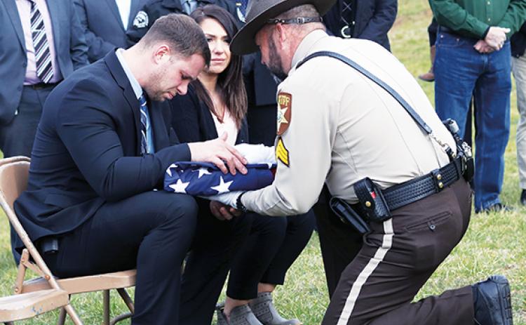 Jared Putnam/editor@cherokeescout.com  Detective Caleb Stiles and his family are presented with the U.S. flag that lay atop Bane’s coffin Monday afternoon.