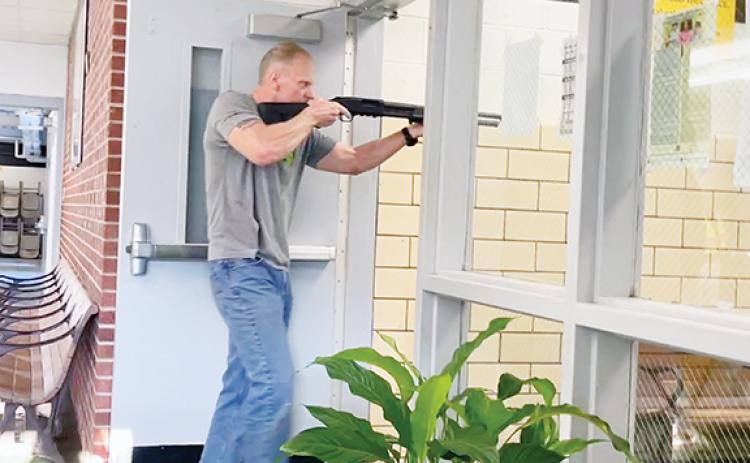 Randy Foster/editor@cherokeescout.com This is only a drill: Greg “Gunny” Chapman, administrative assistant/board liaison with Cherokee County Schools, wields a shotgun with blank rounds as he role-plays an active shooter during a drill at Murphy High School on Aug. 23.