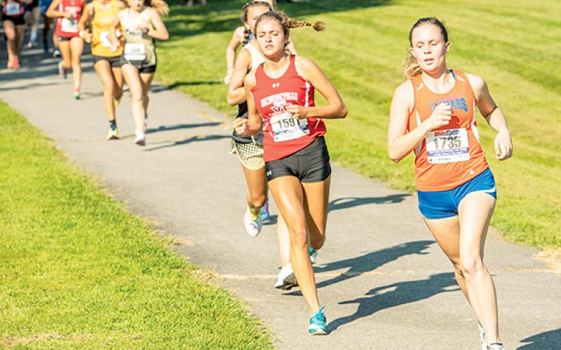 Tri-County Early College’s Sydney Bolyard (right) sets the pace at the Watermelon Run in Cullowhee on Sept. 4. Bolyard has won her last two meets. Photo by Byron Housley