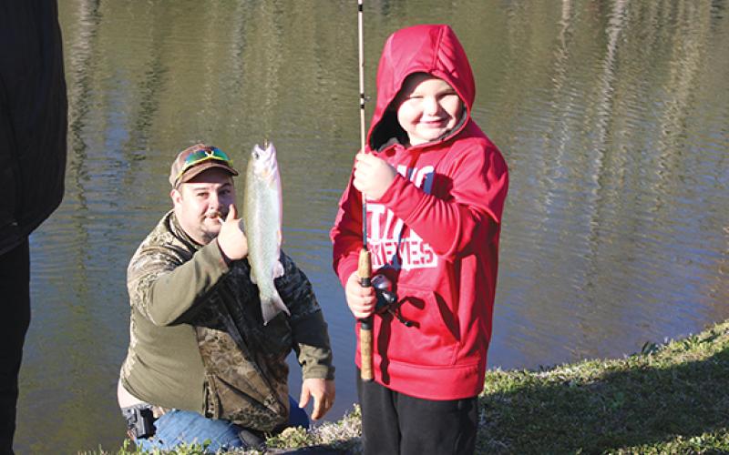 Leo Ware shows off his big catch, as a proud dad gives him a thumbs-up
