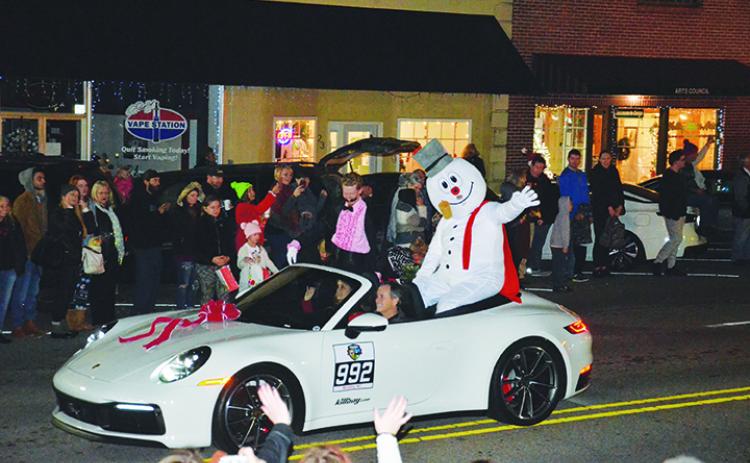 Frosty the Snowman waves to the crowd pf parade watchers as he's escorted down Valley River Avenue during A Very Murphy Christmas on Saturday evening. Photo by Penny Ray
