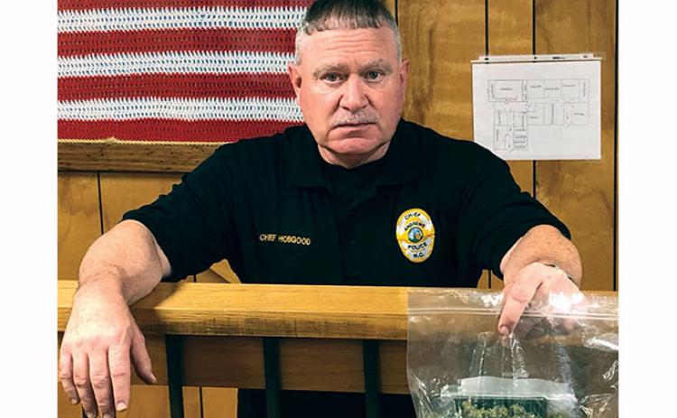 Former chief Michael Hobgood holds a bag of marijuana seized during an arrest last year. He resigned from the Andrews Police Department on July 6.