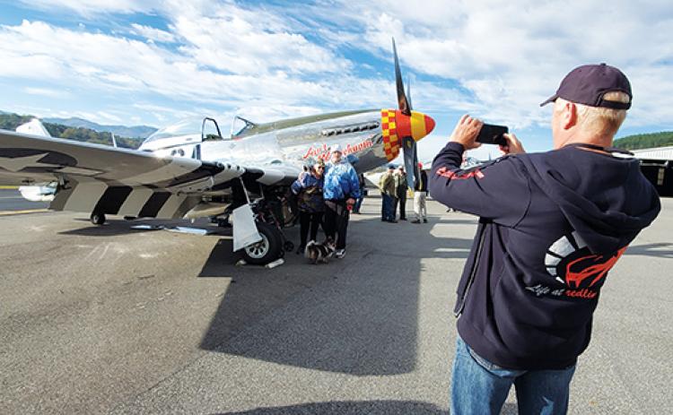 U.S. Air Force veteran Carol Kingsley poses with her son, John, in front of an AT-11 plane as Gary Carter takes their photo. Kingsley is a Korean War veteran who joined when the Air Force started to welcome women. Photo by Samantha Sinclair