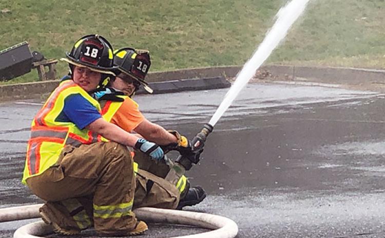 Penny Ray/pennyray@cherokeescout.com  Ranger volunteer firefighters Jewelia Crowe (left) and Dakota Thrower demonstrate the local department’s ability to sustain flow from a static water point in the Cherokee County Department of Social Services parking lot.