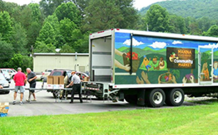 Volunteers like Art St. John and Michael Castaing help unload the MANNA Food Truck at the Hiwassee Dam Senior Center. The center hosts MANNA on the fourth Wednesday of every month to help the community.