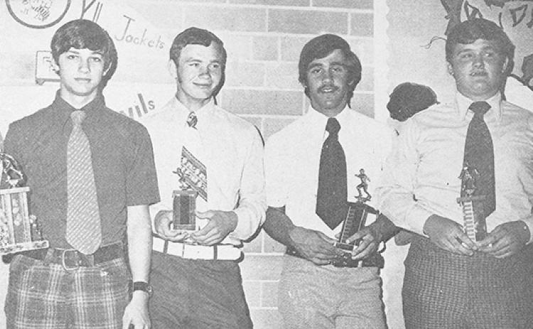 Football coach Gene Young presents four students with trophies (from left) Randy Mason, Donnie Bradley, Danny Hawk and Mike West.