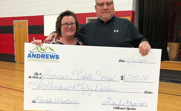 Then Andrews Middle School principal Lance Bristol accepts a $250 donation from Andrews Chamber of Commerce President Gayle Horton in 2019.