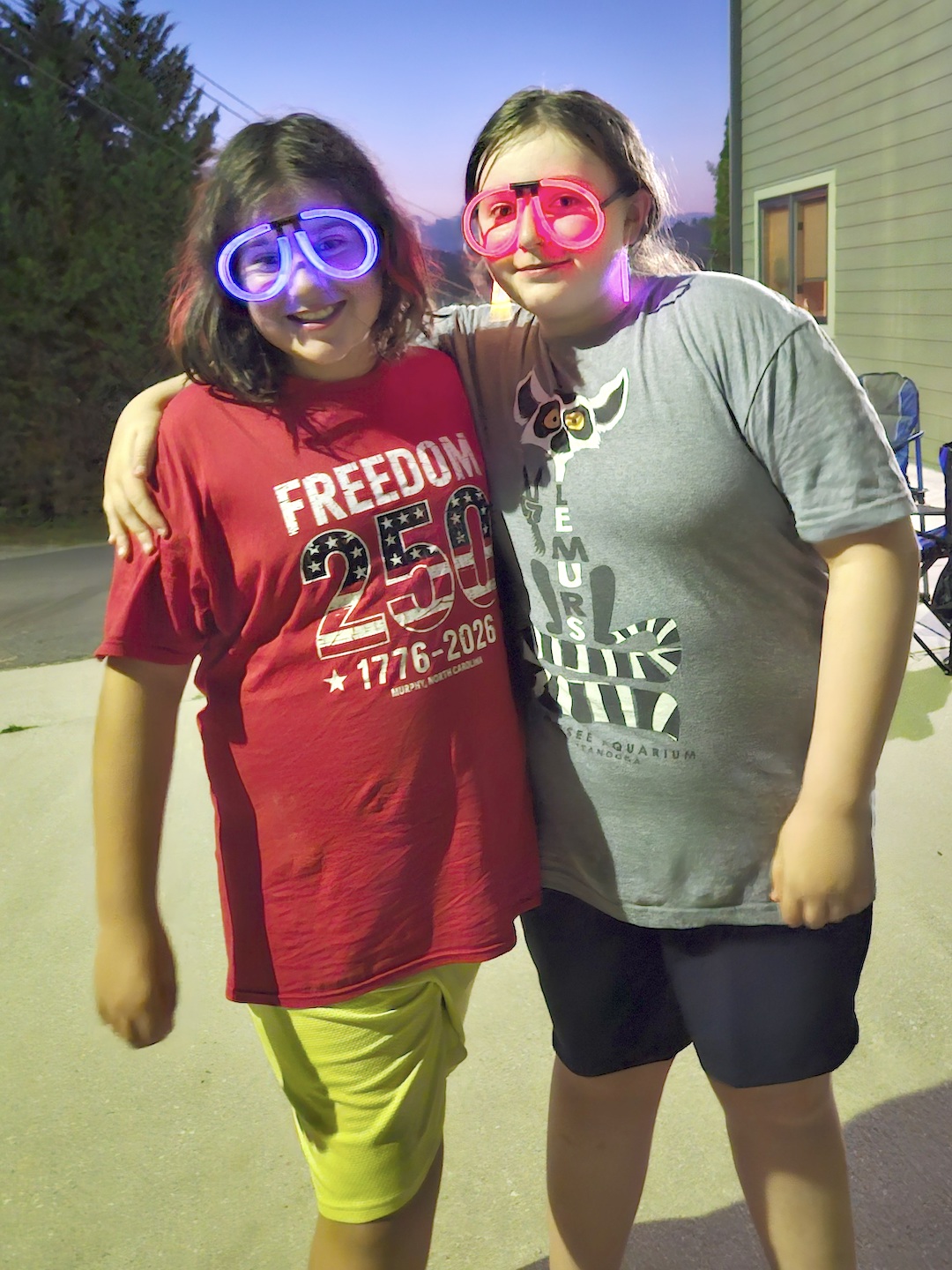 Best Friends, Zella Van Buskirk, 10, of Brasstown, and Abby English, 11, of Murphy have fun with glow sticks before the fireworks show on Saturday. Photo by Stacy Van Buskirk/Cherokee Scout