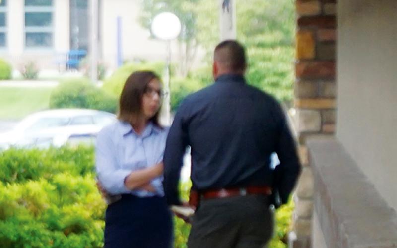 Randy Foster/editor@cherokeescout.com Then-Cherokee County Sheriff Dustin Smith and District Attorney Ashley Welch confer privately ahead of a press conference on the day Detention Officer Francisco Flattes was killed during an escape attempt. Welch listed that homicide among several other incidents as cause for Smith to resign.