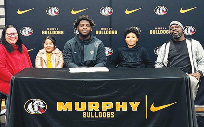 Heather Watson/ Contributing Photographer Murphy High School senior Janthony Gooden (middle) signed a letter of commitment to continue his football and academic career at Catawba College in Salisbury. The standout lineman signed the letter on Feb. 4. Janthony is joined by (from left) Angela Gooden, Nova Gooden, Neiko Gooden and Anthony Gooden.
