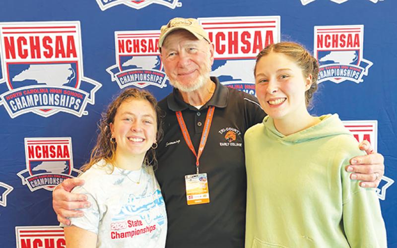 Chris Crayton/Contributing Photographer Tri-County Early College swimmers Fern Crayton (left) and Sophia Evans (right) competed at the state meet on Feb. 14 in Cary. The team is coached by Frank Bachteler (middle).