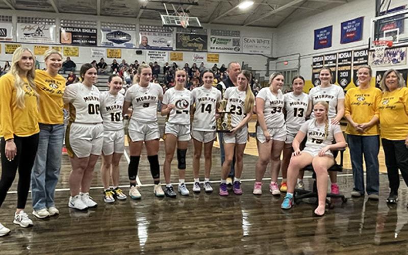 Wendy Leatherwood/Contributing Photographer The Murphy JV girls basketball team won the Big Smoky Mountain Conference championship on Thursday night. From left are Ella Pinkerton, Grace Ledford, Nichole Roberts, Maddy Debty, Kylee Koop, Ryle Howard, Valorie Jordan, head coach Terry Jones (behind), Bella Kent, Peyton Harding, Kensley Yarbro, Taylor Smith, Lauren Jones, Patsy Howard and Kathy Kent.