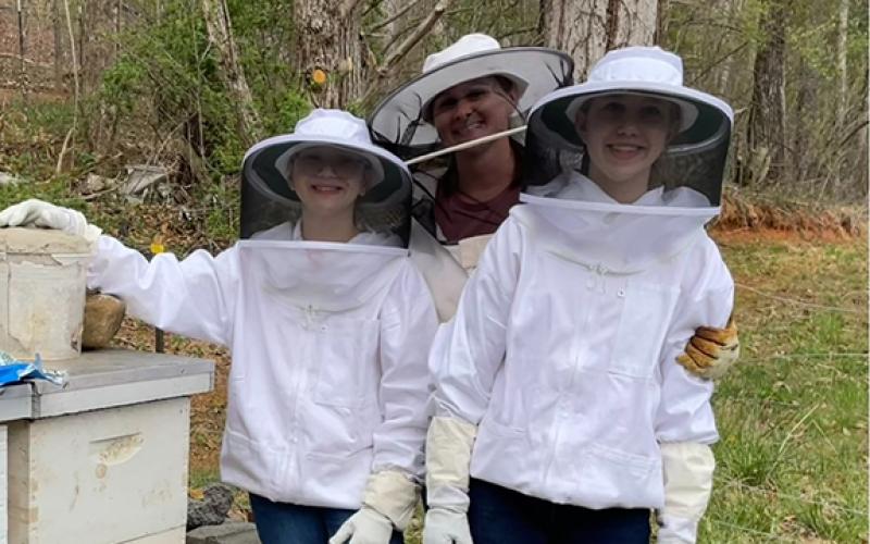 Cameron Green enjoys beekeeping with her children and has made the activity a family affair. The three just installed a new package of bees after the girls finished their first beekeeping class. From left are Kalette, Cameron and Danika Green.