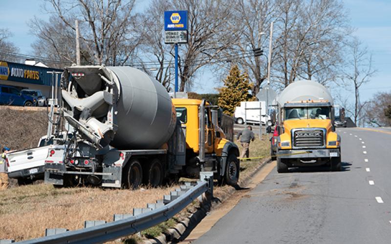 Randy Foster/editor@cherokeescout.com A cement truck pulls another cement truck after it got stuck on soft ground near the intersection of Peachtree Street and U.S. 19/74 in Murphy on Friday.