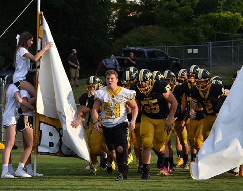 Injured senior Brady Satterfield leads the Bulldogs onto the field for their season opener against the Pisgah Black Bears. Photo by Noah Shatzer