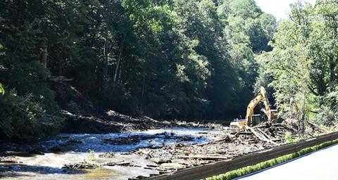 Contractors using heavy equipment work to remove debris from the Nantahala River. 