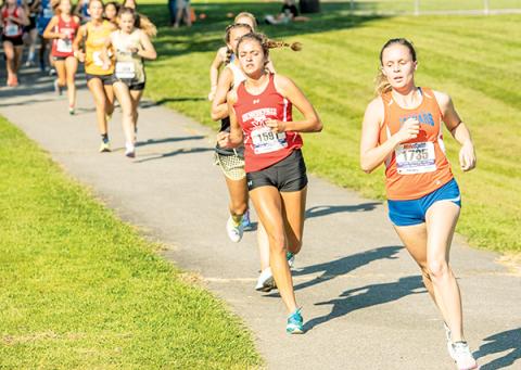 Tri-County Early College’s Sydney Bolyard (right) sets the pace at the Watermelon Run in Cullowhee on Sept. 4. Bolyard has won her last two meets. Photo by Byron Housley