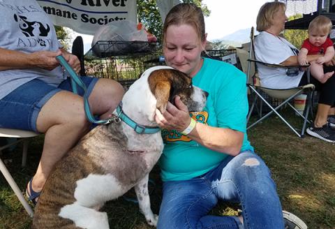 At Paws-A-Palooza, Valley River Humane Society animal shelter manager Kirsty Waller cuddles with Brock, one of the dogs saved by medical treatments provided by Andrews Veterinary Hospital.