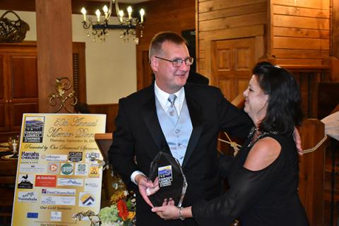 Tim Radford, owner of WKRK radio, smiles after receiving the Cherokee County Chamber of Commerce’s 2019 Citizen of the Year award from chamber Executive Director Sherry Raines on Thursday night.