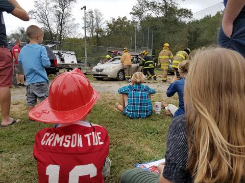 Children watch as teams of volunteer firefighters practice extraction skills and show the difference in tools during the Car Extraction Race at the Ranger Volunteer Fire Department on Saturday. "They're ripping the doors off?" one child exclaimed as the volunteers carefully removed pieces of the car.