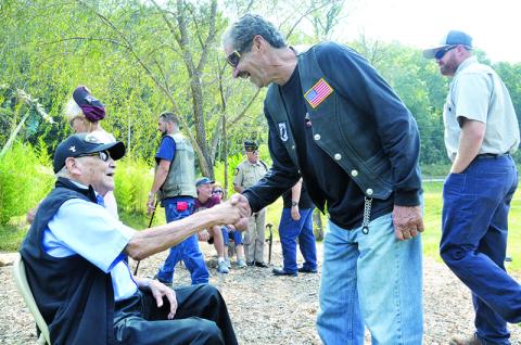 Patrons at the Veterans Educational Appreciation Day event show respect to 93-year-old U.S. Army veteran Reuben Taylor (left), who fought in the European Theatre of World War II.