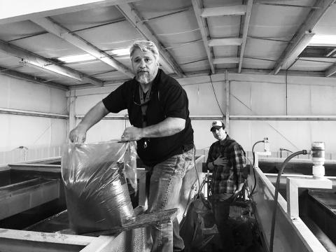 Andrews Mayor James Reid pours anthracite coal into the filters inside Andrews' water treatment plant. Photo by Penny Ray