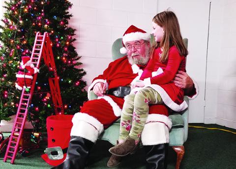 During the Cruise Night for the Kids Community Christmas Party, 8-year-old Daisy Siler asks Santa Claus for an iPhone 11 for Christmas. Photo by Samantha Sinclair