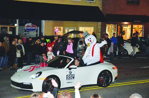 Frosty the Snowman waves to the crowd pf parade watchers as he's escorted down Valley River Avenue during A Very Murphy Christmas on Saturday evening. Photo by Penny Ray