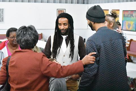 Raven Lance, Kilian Lance and Aaron Jackson bow their heads as Roy Stephenson, minister with Murphy Church of Christ, provides the “Prayer of Unity” during the 28th annual Martin Luther King Jr. Prayer Breakfast on Monday morning in the Texana Community Center. Photo by Samantha Sinclair