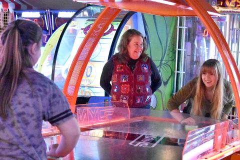 During the Big Brothers Big Sisters Christmas Party at the UltraStar Multi-tainment Center in December, Sallie Sompayrac watches Emily Barnes plays air hockey with her Little. Photo by Samantha Sinclair