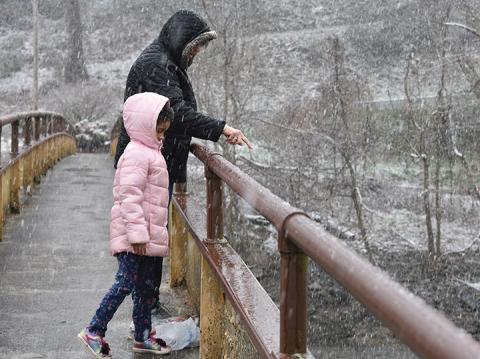 While schools were closed Friday, Karen Crubaugh helped one of her neighbors who had to work by watching her daughter, Mayla Ramos. She took the girl who had recently moved from California to Konehete Park to play in the snow and feed the ducks. Photo by Samantha Sinclair