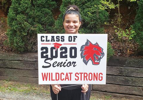 Jazlin Raxter beams as she holds the yard sign personally delivered to her house by Andrews High School Principal Lisa Fletcher.