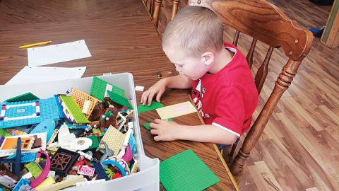 Isaac Morris carefully arranges his bricks for a creation.