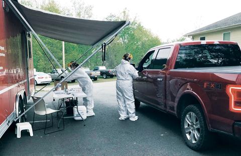 Cherokee County Health Department officials Alicea Mealer and Rebecca Hand (from left) test a critical infrastructure worker for COVID-19.