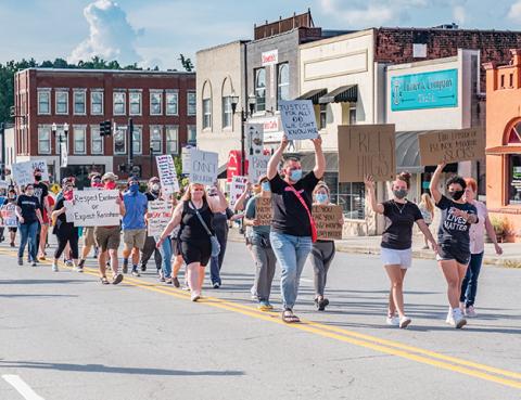 Organizers Jake Reed, Emily Mills, and Te’Lor Allen of Murphy lead marchers down Peachtree Street on Thursday night to send a peaceful message that all races deserve to be treated equally in America. Photo by Sam Jokich