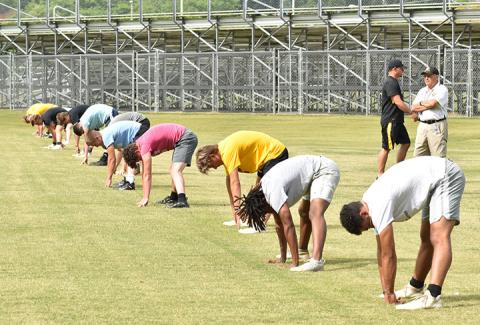 Murphy coach David Gentry watches as the Bulldogs skill players spread out and stretch prior to conditioning drill work during the first week of workouts on June 17. Photo by Noah Shatzer