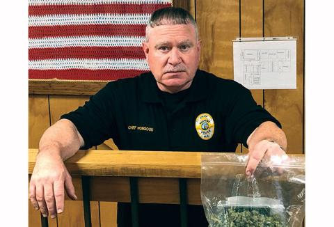 Former chief Michael Hobgood holds a bag of marijuana seized during an arrest last year. He resigned from the Andrews Police Department on July 6.