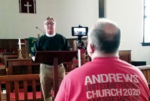 Jeanne Powell/For the Cherokee Scout Robby Morris records the Rev. Tom Jolly as he preaches his sermon in the sanctuary of Andrews United Methodist Church.