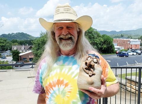 Local potter Rob Withrow holds the face jug he is giving to North Carolina’s first lady, Kristin Cooper.