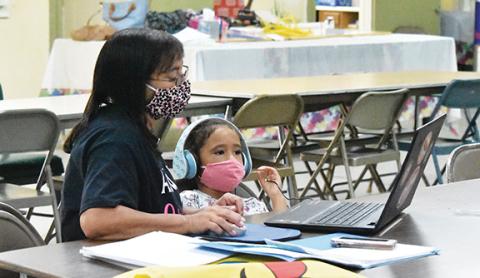 Samantha Sinclair/scoutingaround@cherokeescout.com Mattie Ann Brown assists granddaughter Kameryn Brown with her schoolwork at the Texana Community Center.