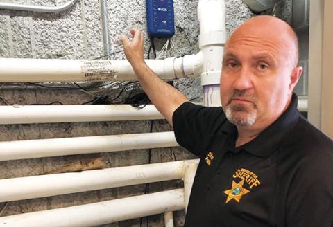Cherokee County Sheriff Derrick Palmer explains the jail’s new plumbing system to foil inmates’ flooding.  Photo by Penny Ray
