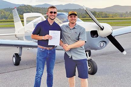 After getting his license, Seth Fullerton is congratulated by Grady Flynn, one of the instructors at the airport.