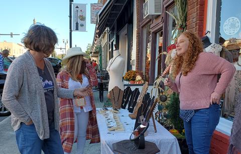 Photo by Samantha Sinclair: Jewelry artisan Cindy Fife talks about her artwork to passers-by at Art Walk Friday nigh.