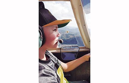 Timothy Raxter flies a plane for the first time with assistance from airport manager Garland Trull. The Western Carolina Youth Aviation Foundation is hoping to give more kids the same opportunity Raxter had.